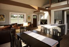 a kitchen and living room are separated by an open floor plan, while the dining table is set for four