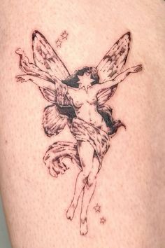 a small tattoo on the back of a woman's shoulder, depicting a fairy