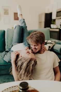 Laughing Couple during an In-Home Couple Photoshoot Sofa Poses Photo Ideas Couple, Inside Couple Photoshoot, Couple Photoshoot Intimate Bedroom, Couple On Bed Pose, Couples Comfy Photoshoot, Jeans Photoshoot Ideas Couple, Intimate Indoor Couple Shoot, Couple Poses Photography Indoor, Couch Photoshoot Ideas Couple