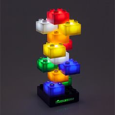 a multicolored lego light up tower on a black surface with the lights turned on