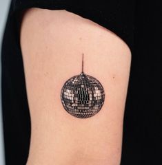 a woman's back shoulder with a disco ball tattoo on the left side of her arm