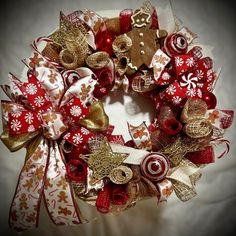 a red and gold christmas wreath with gingerbreads, candy canes, and pretzels