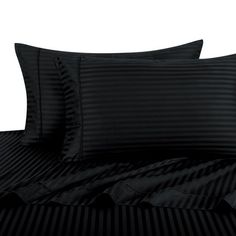 a bed with black striped sheets and pillows