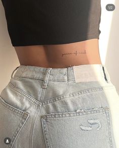 the back of a woman's stomach with her name tattooed on it