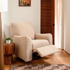 a living room with a chair and rug on the wooden floor next to a door