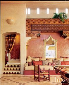 a living room filled with furniture and a large mirror on the wall over a pool table