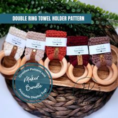 four wooden rings with labels on them sitting in a basket next to some greenery