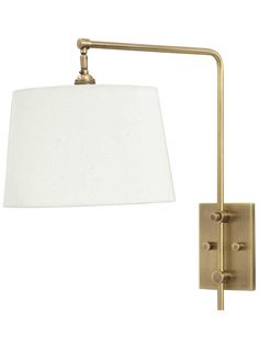 a wall light with a white shade on the arm and a gold metal finish frame