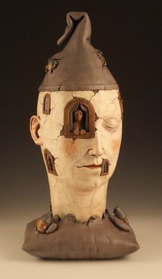 a ceramic sculpture of a man's head with his eyes closed