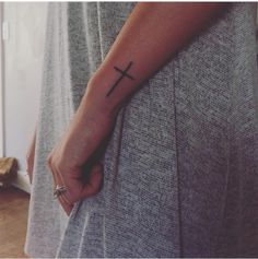 a person with a cross tattoo on their arm