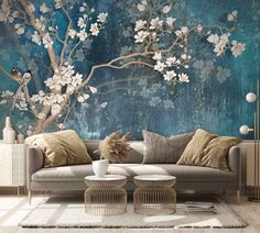 a living room scene with focus on the couch and wallpaper that looks like it has blossoming trees