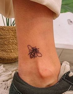 a small bee tattoo on the ankle