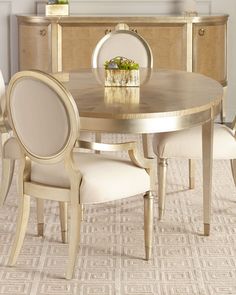 a dining room table with chairs and a vase on the sideboard in front of it