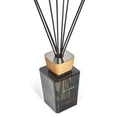 an image of a reed diffuser with wood and metal sticks in it on a white background