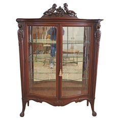 an antique china cabinet with glass doors and carvings