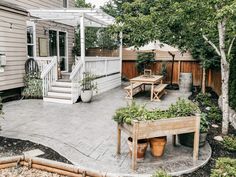 an outdoor patio with potted plants and wooden benches