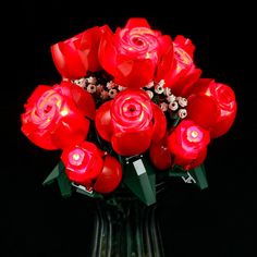 a vase filled with lots of red flowers