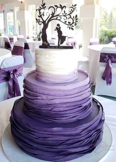 a wedding cake with purple ruffles and a silhouette of a bride and groom on top