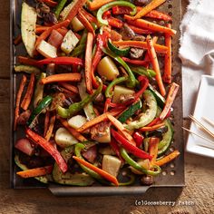 a tray filled with vegetables on top of a wooden table