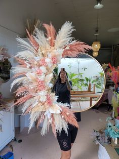 a woman is taking a selfie in front of a mirror with feathers on it