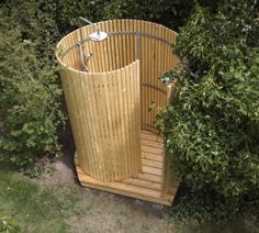 a wooden sauna in the middle of some bushes