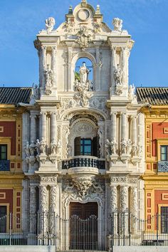 an ornate white building with statues on the front and balconys above it's doors