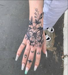 a woman's hand with tattoos and flowers on it