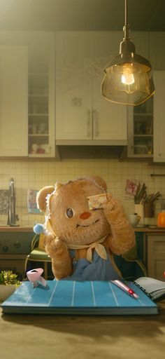 a brown teddy bear sitting on top of a blue tray next to a light fixture