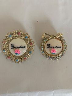 Sweet vintage Grandma pins. They are adorable for a special Grandma.  The larger one is 1 1/4 inches round and the smaller one is 1" round.  All the rhinestones are intact, and they are very colorful.  The smaller one is embellished in rhinestones an the larger one has different colors.  They both have a sweet rose under the word Grandma. Grand Est, Halloween Shopping, Brooch Pin, Brooches, Bathing Beauties, Thing 1, Electronic Accessories, Purses And Bags, Music Clothes