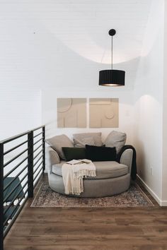 a living room with white walls and wood flooring on the bottom level is shown