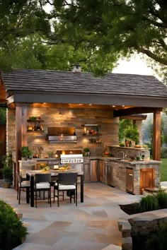 an outdoor kitchen and dining area is lit up at night