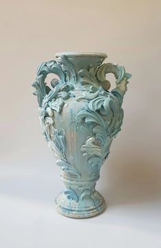 a large blue vase sitting on top of a white table