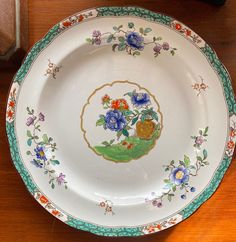 a plate with flowers painted on it sitting on a table