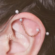 a close up of a person's ear with pearls on it