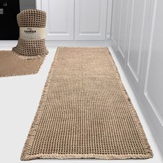 the rug is on the floor in front of the door and next to it are two rolls of burlap