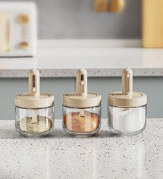 three glass containers with lids on a counter