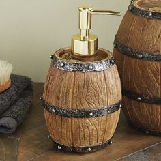 two wooden barrel shaped soap dispensers on a table next to towels and a brush