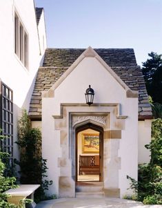 an entrance to a house with a bench in the front yard