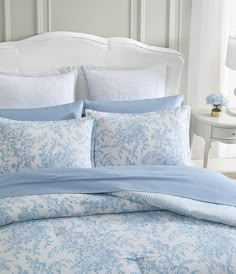 a bed with blue and white comforters in a bedroom