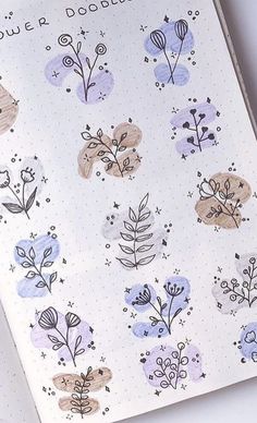 an open notebook with flowers and plants drawn on the pages, sitting on top of a table