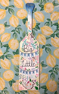 a painted bottle with the words big little on it and lemons in the background