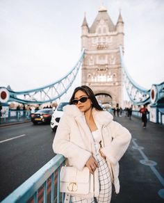 a woman standing in front of a bridge