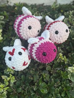 three crocheted animals are sitting in the bushes