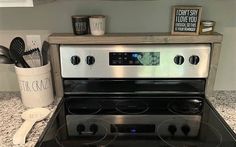 a stove top oven sitting on top of a kitchen counter next to utensils