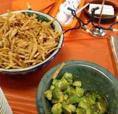 two bowls filled with food sitting on top of a table next to other plates and utensils