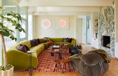 a living room filled with green couches and chairs next to a fire place in the corner