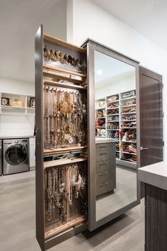 an open closet with lots of jewelry inside of it and a washer dryer in the background