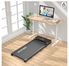 there is a treadmill on the floor in front of a desk with a monitor