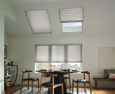 a dining room table with two chairs and a window covered in blinds over the windows