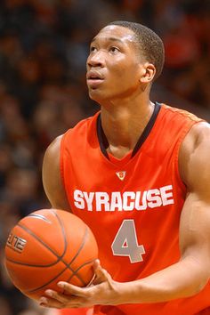 a young man holding a basketball in his right hand and wearing an orange uniform with the number 4 on it